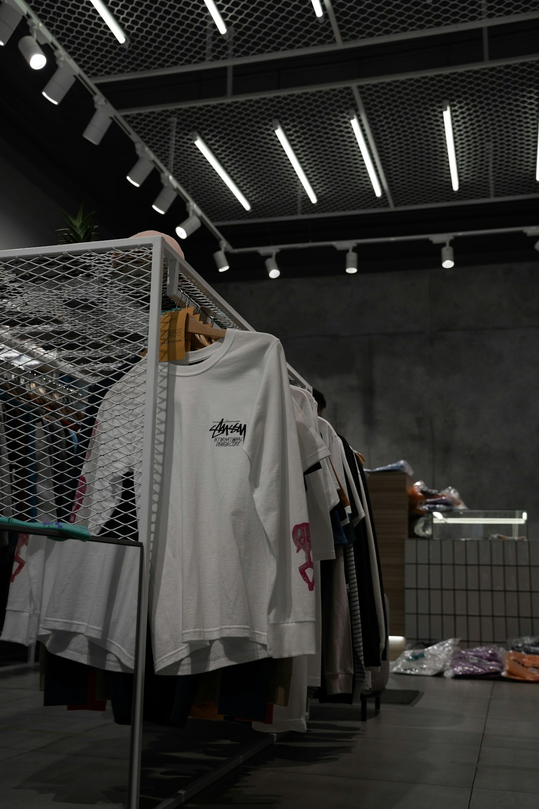 white-polo-shirt-hanging-on-gray-metal-rack-ro0pnxcpcus